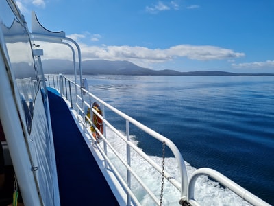Under the blue sky during the day, the ship sailing on the sea of blue and white
